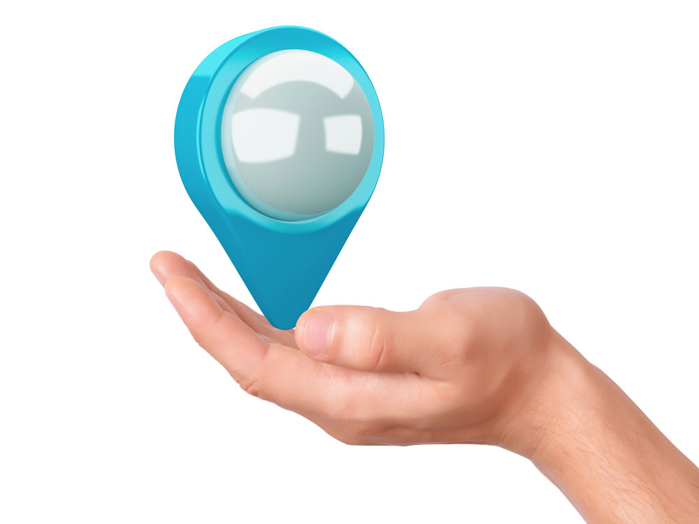 Hand holding a blue location pin symbol, representing local SEO and online visibility for businesses.