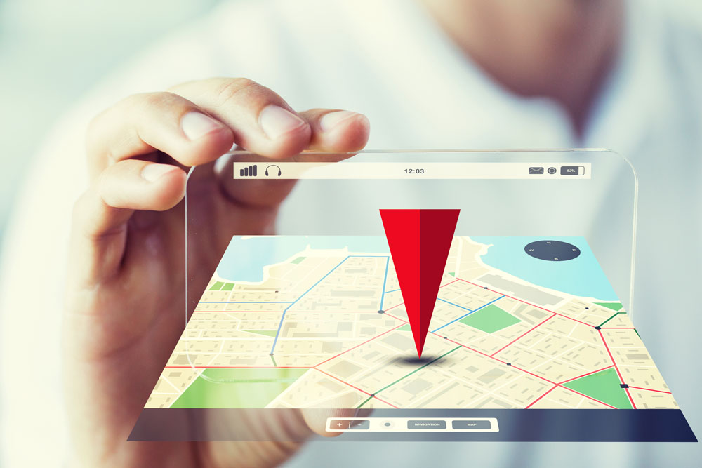 Hand holding a transparent digital map with a prominent red location pin, symbolising navigation and local search visibility for SEO services.