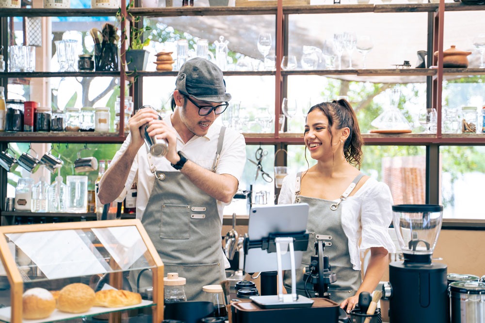 Baristas in a café preparing drinks, showcasing local business atmosphere and customer engagement.